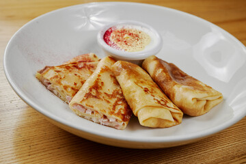 pancakes with cheese and ham, served with sauce