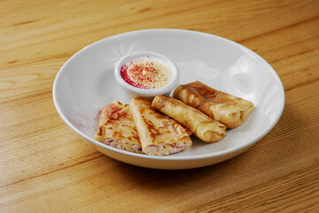 pancakes with cheese and ham, served with sauce