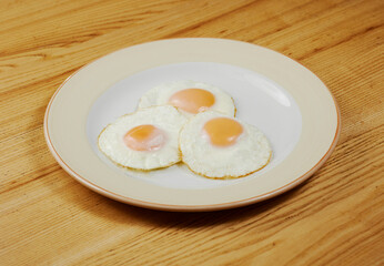 fried scrambled eggs from three eggs on a wooden table