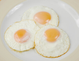 fried scrambled eggs from three eggs on a wooden table