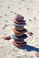 Fototapeta na wymiar Pyramid of stones on a sandy beach. Zen balance stones.