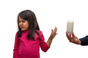 Elementary school girl turns down a glass of milk offered to her on a white background