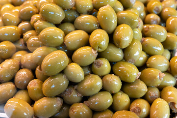 Green fresh olives close up on market, food background