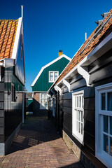 Walking on sunny day in small Dutch town Marken with wooden houses located on former island in North Holland, Netherlands