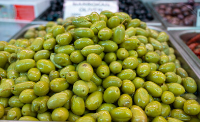 Green fresh olives close up on market, food background