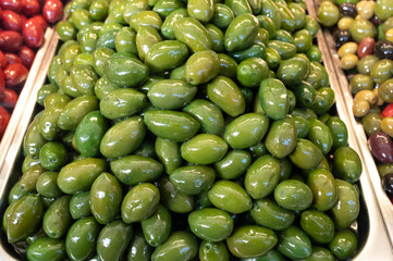 Green fresh olives close up on market, food background