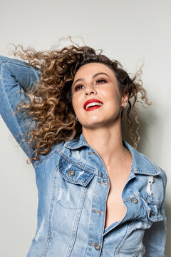 Studio shot of proud young girl with perfect light brown skin and beautiful curly hair in empowerment pose on a white background.