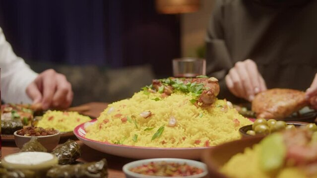 Muslim family dinner, eating togeher, Arabian cuisine. Ramadan, religious holiday, holy month. Couscous with eggplant, delicious rice and meat on table. Traditional middle eastern culture, worship. 