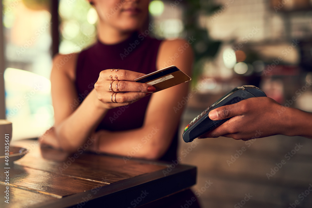 Poster swipe it off my cheque account. closeup shot of a woman paying using nfc technology in a cafe.