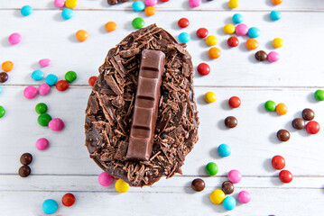 Easter concept, delicious chocolate filled easter egg on white background with confetti.
