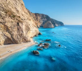 Luftaufnahme des blauen Meeres, Felsen, Sandstrand mit Menschen an sonnigen Tagen im Sommer. Porto Katsiki, Insel Lefkada, Griechenland. Schöne Landschaft mit Meeresküste, Steinen im azurblauen Wasser, Wellen, Himmel. Ansicht von oben © den-belitsky