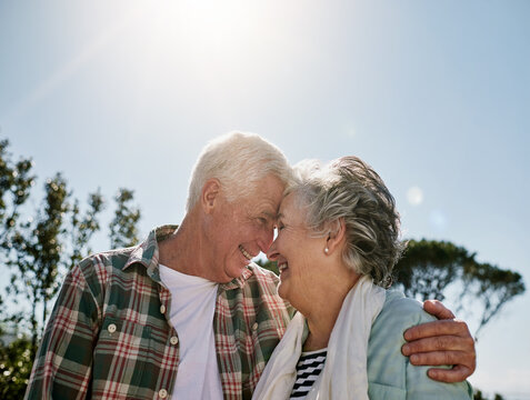 Honey, youre my world. Shot of a happy senior couple relaxing together outdoors. - Powered by Adobe