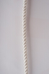 beautiful white rope on a white background with a light shadow and empty space on the sides for text