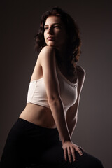 Beautiful teenage girl studio portrait against dark background..