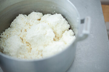 Cottage cheese in saucepan. Food in dining room. Cooking lunch in school kitchen. Dairy products. Chef's job.