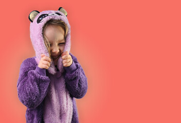 Little girl toddler child wear hooded purple pajamas smiling on pink background