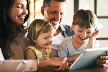 Adding screen time to family time. Shot of a young family of four using a digital tablet together at home.