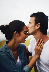 Forehead kisses, the most beautiful feeling in the world. Shot of an affectionate young couple spending a romantic day in the park.