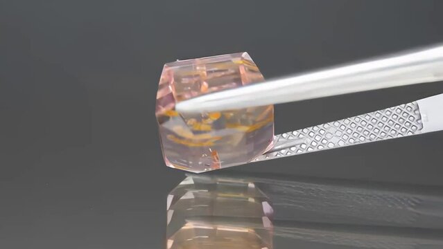 natural bi-color polychromatic tourmaline octagon cut in the tweezers