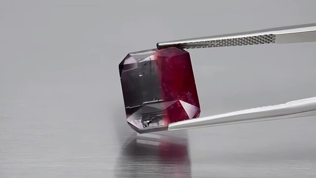 natural bi-color polychromatic tourmaline octagon cut in the tweezers