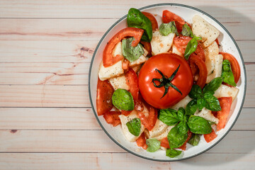 Classic Italian caprese salad of mozzarella, tomato and basil with olive oil and vinegar.