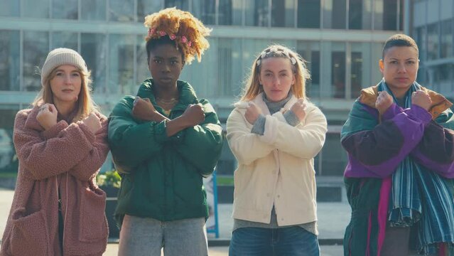 Group of female protestors with arms crossed on demonstration march in city- shot in slow motion