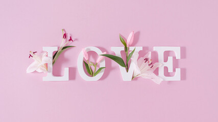 Colorful love background. Floral Greeting card. Happy Women's Day. Spring flower flat lay holiday background with word Love. Nature Trendy Design. Happy Valentine's Day.