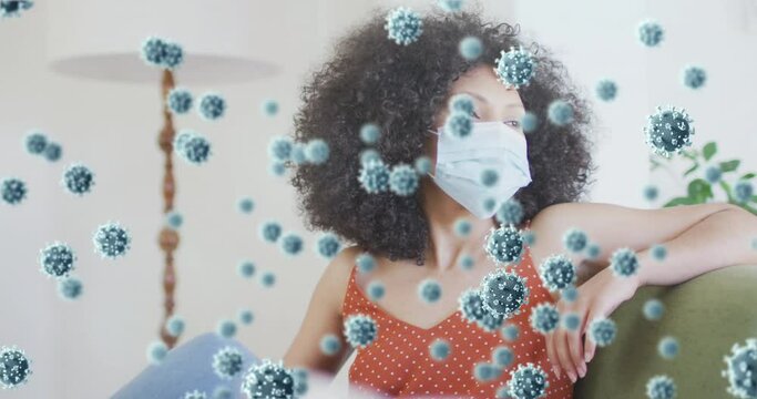Animation of virus cells over african american woman with face mask