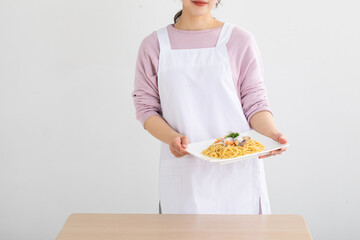 パスタ皿を持つ女性　cooking