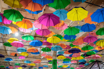 Fototapeta na wymiar Multi-colored umbrellas suspended from the ceiling