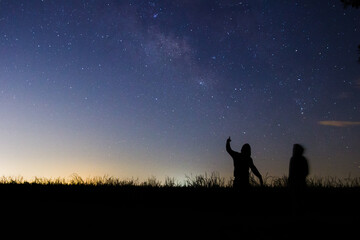 People standing in front of milky way