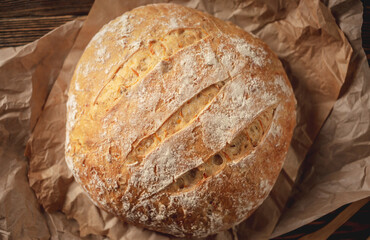 Homemade natural bread with a Golden crust on a napkin on an old wooden background. Baking bakery products. Rustic style