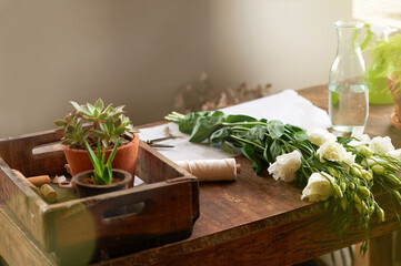 Awaiting their place in your home. Shot of a bunch of flowers and other plants lying on a florists worktable.