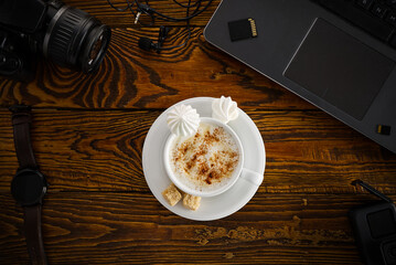 Work from home. desk office with laptop and camera, coffee cup on wood table. Flat lay top view.
