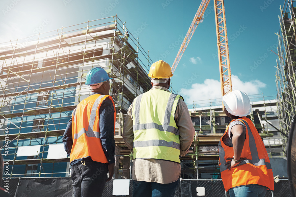 Poster Creating thriving communities one building at a time. Shot of a group of builders assessing progress at a construction site.