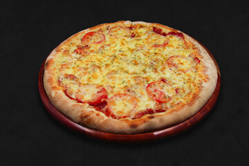 Tuscany pizza isolated on black background, with a wooden plate