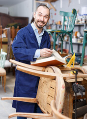 Fototapeta na wymiar Craftsman looking at album in furniture restoration workshop