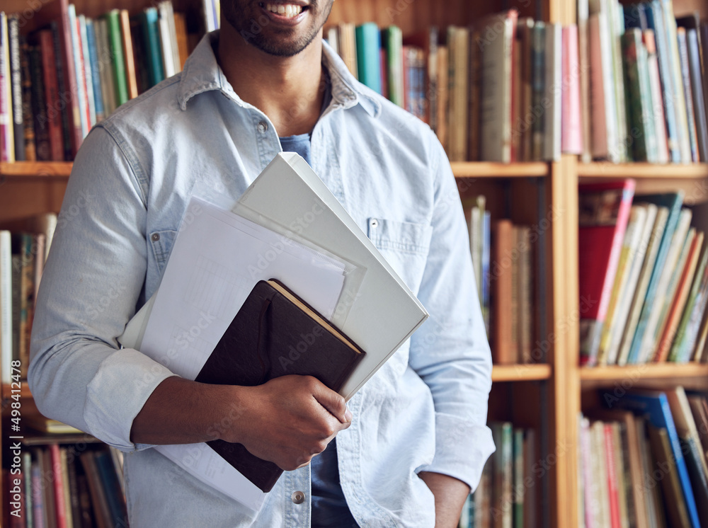 Poster The beginning of a bright future. Shot of an unrecognisable man studying in a library at university.