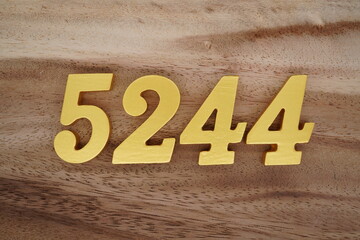Golden Arabic numerals on a real brown and white wooden floor number 5244