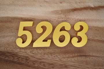 Golden Arabic numerals on a real brown and white wooden floor number 5263