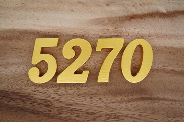 Golden Arabic numerals on a real brown and white wooden floor number 5270