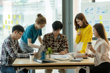 Group of young Asian business people meeting in casual wear working together on new project.