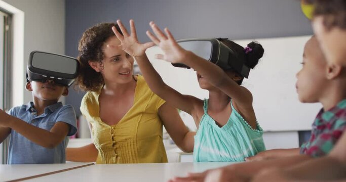 Video of happy caucasian female teacher and class of diverse pupils wearing vr headsets