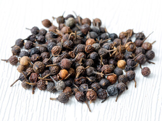 handful of cubeb tailed pepper macro background. Piper cubeba top view, close up on white...