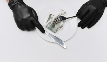 Business lunch concept. Two thief's hands in black gloves hold fork with knife and cut off a piece...