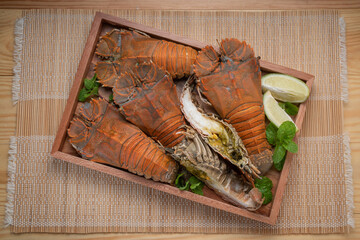 Flathead lobster on wooden background, Flathead lobster or Mantis shrimp on wooden plate ready to...