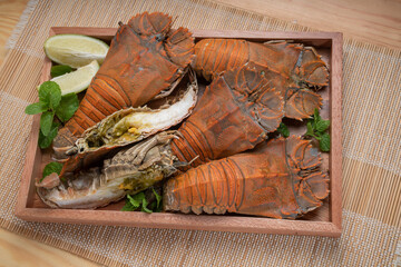 Flathead lobster on wooden background, Flathead lobster or Mantis shrimp on wooden plate ready to...