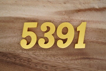 Golden Arabic numerals on a real brown and white wooden floor number 5391