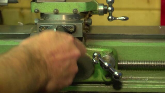 turning the feed handle on a lathe, mid shot