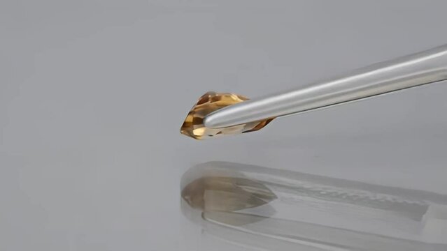 natural gemstone yelow zircon pear cut in the tweezers